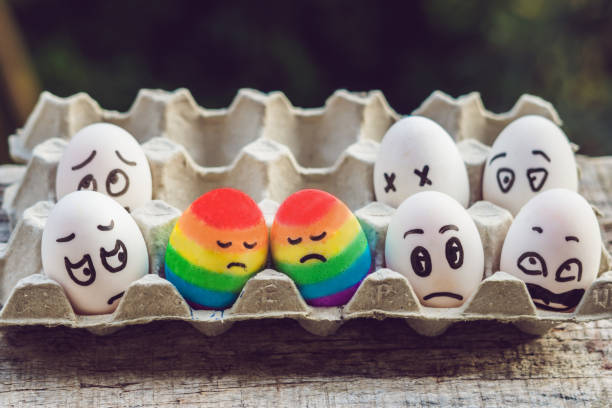 conceito de discriminação gay. dois ovos de arco-íris sob a forma de um casal homossexual. e condenando as pessoas ao redor - homofobia - fotografias e filmes do acervo