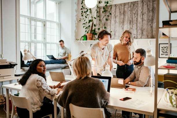 Discussion in start-up company between multi-ethnic employees Multi-ethnic teamwork in coworking office culture stock pictures, royalty-free photos & images