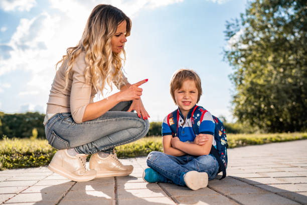 Disgruntled boy with his mom in the park stock photo