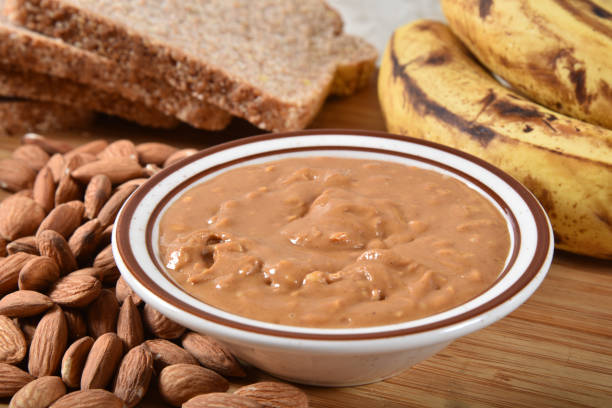 Dish of healthy almond butter A dish of fresh almond butter with ripe bananas and sprouted multi-grain bread almond butter stock pictures, royalty-free photos & images