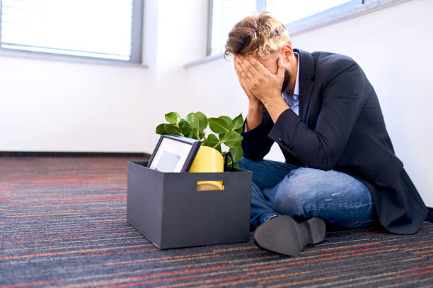 Dismissed millenial sitting on the office floor stock photo