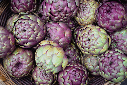 Close up image of fresh artichokes in a row at the food market.