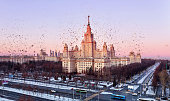 Dissolution texture of aerial panoramic view of winter campus of famous Russian university with snowed trees in sunset Moscow