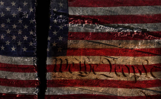Distressed US flag split in two with We The People constitution text stock photo