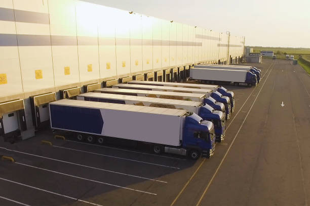 gudang distribusi dengan truk menunggu pemuatan - pengangkutan barang potret stok, foto, & gambar bebas royalti