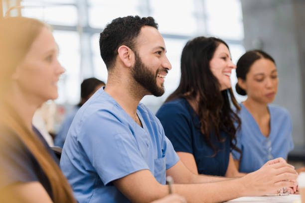 Diverse class of interns listen to lecture A multi-ethnic group of medical school interns listen to a lecture by and unseen professor. medical student stock pictures, royalty-free photos & images