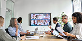 istock Diverse employees on online conference video call on tv screen in meeting room. 1333390966