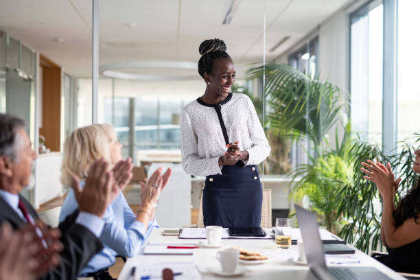 Diverse Group of Executives Applauding African Female CEO stock photo