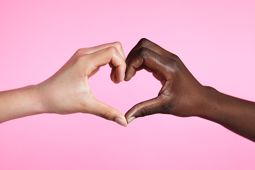 Diverse hands with love sign on pink background