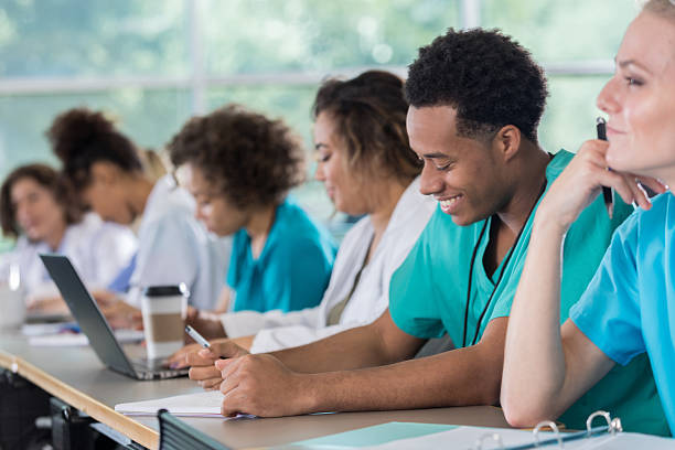 Diverse pre-med students take notes during class Diverse male and female medical students take notes during class. medical student stock pictures, royalty-free photos & images