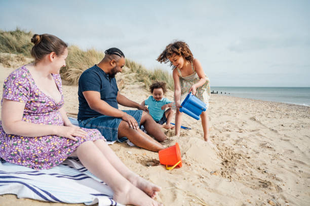 Diverse young British family playing at the beach stock photo