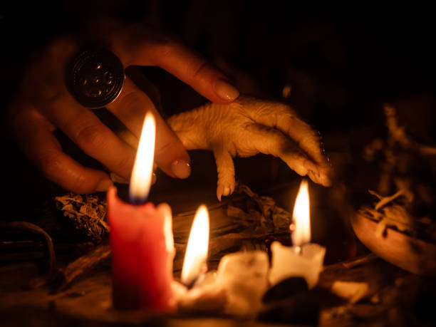 divination à l'aide de pieds de poulet et d'herbes sèches. la lumière des bougies sur la vieille table magique. attributs de l'occultisme et de la magie - the game photos et images de collection