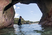 日本でのダイビング、洞窟の10代の少年、水中、ウェットスーツとシュノーケル、海藻と泡の中、勝浦、千葉、日本