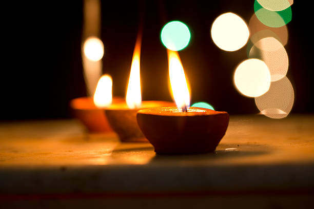 Close-up of oil lamps with candle illuminating at night representing the concepts of Diwali celebration.