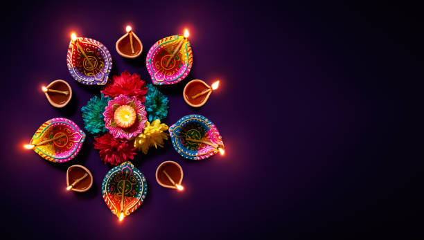 Diwali oil lamp Colorful clay diya lamps with flowers on purple background india photos stock pictures, royalty-free photos & images