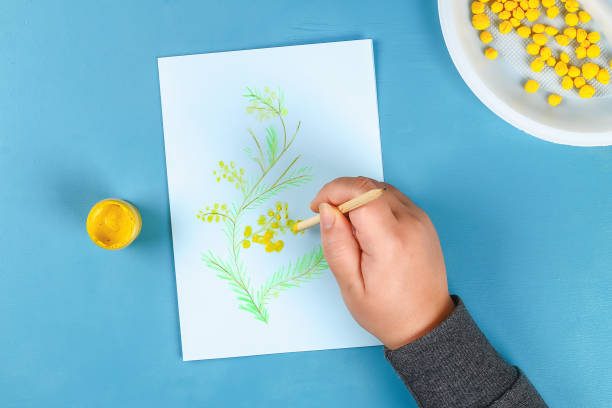 Diy greeting card with mimosa flowers paper balls for March 8 on blue background. stock photo