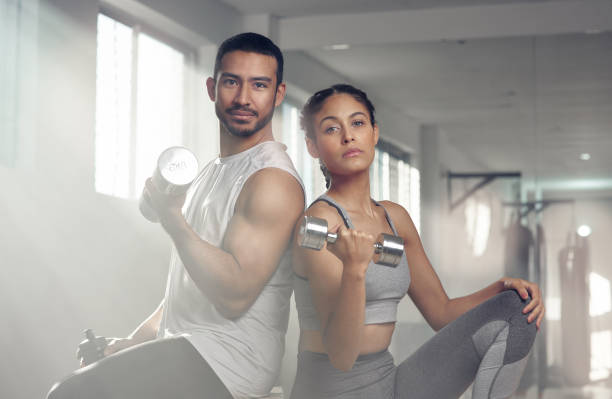 Do a little more and complain a little less Cropped shot of two young athletes holding dumbbells less weight stock pictures, royalty-free photos & images