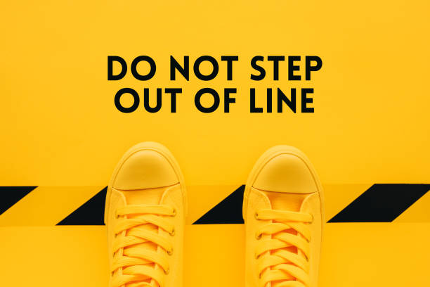 Do not step out of line Do not step out of line, person in yellow sneakers breaking the rules and acting in an inappropriate or unacceptable way rule breaker stock pictures, royalty-free photos & images