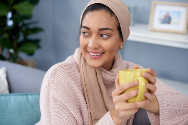 I do quite enjoy these quiet moments with coffee Shot of a young woman enjoying a cup of coffee while relaxing at home hot arab women stock pictures, royalty-free photos & images