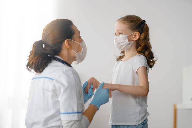 Doctor and child wearing facemasks stock photo