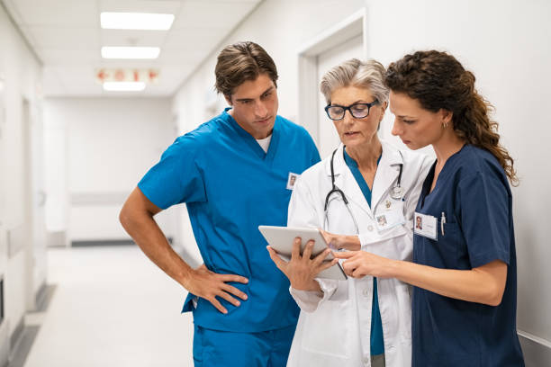Doctor and nurse discussing patient case at hospital stock photo