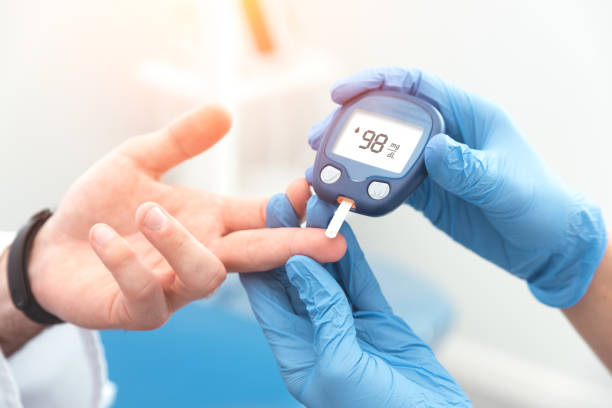 Doctor checking blood sugar level with glucometer stock photo