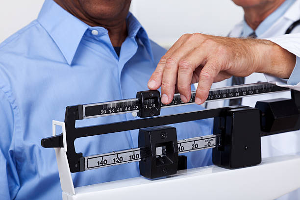 Doctor Checking Weight XXXL.  Doctor checking weight of patient. gchutka stock pictures, royalty-free photos & images