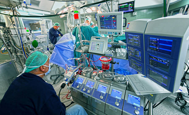 Doctor checks data of cardiopulmonary bypass machine stock photo