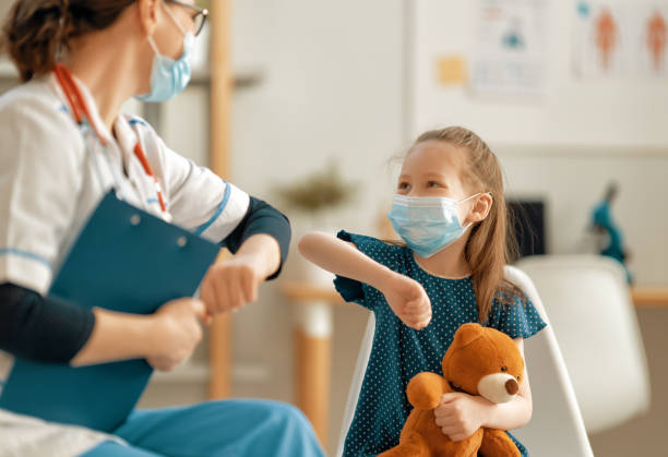 Doctor, child and mother wearing facemasks stock photo