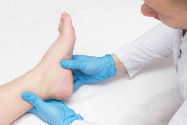 Doctor examines the patient's leg with heel spurs, pain in the foot, white background, close-up, plantar fasciitis Doctor examines the patient's leg with heel spurs, pain in the foot, white background, close-up, plantar fasciitis, inspection plantar fasciitis stock pictures, royalty-free photos & images