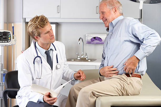 doktor untersuchen männliche patienten mit schmerzen auf der hüfte - hüfte stock-fotos und bilder