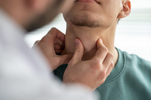 Doctor examining patient's throat at clinic