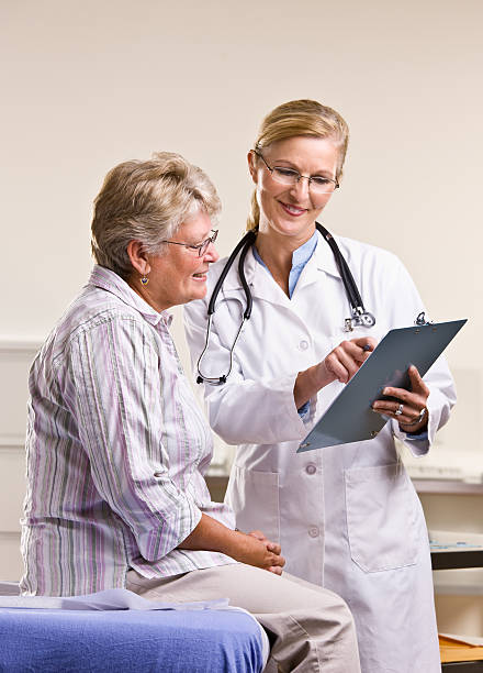 Doctor explaining medical chart to senior woman stock photo