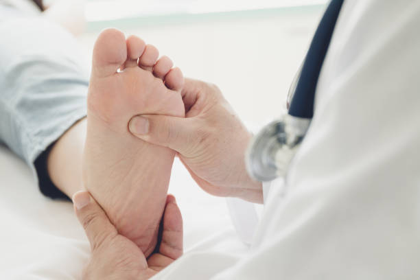 doctor giving a patient foot treatment - pes imagens e fotografias de stock