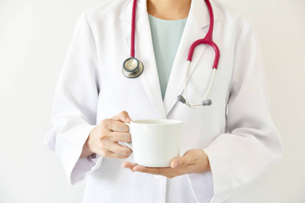 Doctor hand holding coffee, Daily caffeine intake recommended. stock photo