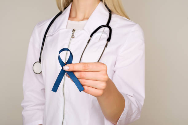 Doctor hands holding blue ribbon, diabetes and Colorectal Cancer Awareness Doctor hands holding blue ribbon, diabetes and Colorectal Cancer Awareness - Image diabetes awareness month stock pictures, royalty-free photos & images