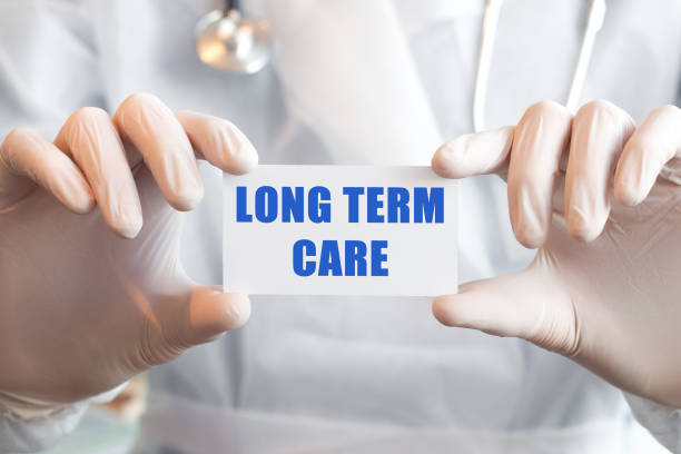 의사가 텍스트 long term care, 의료 개념으로 카드를 들고 - 긴 뉴스 사진 이미지