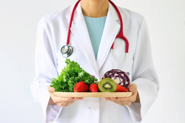 Doctor holding fresh fruit and vegetable, Healthy diet, Nutrition food as a prescription for good health. stock photo