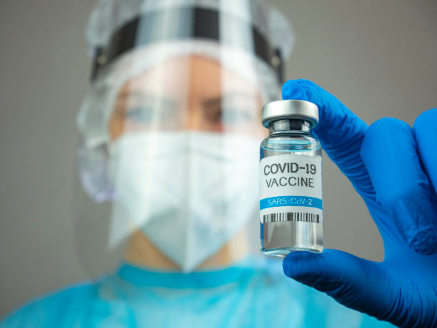 Doctor holds COVID-19 vaccine in hand. Close up of vial. stock photo