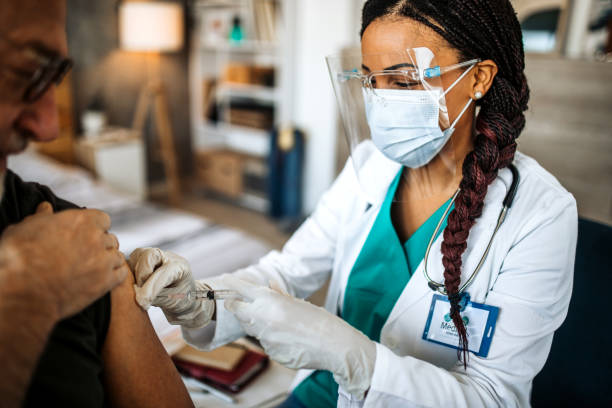 lekarz wstrzykiwanie szczepionki przeciw grypie do ramienia pacjenta - at home covid test zdjęcia i obrazy z banku zdjęć