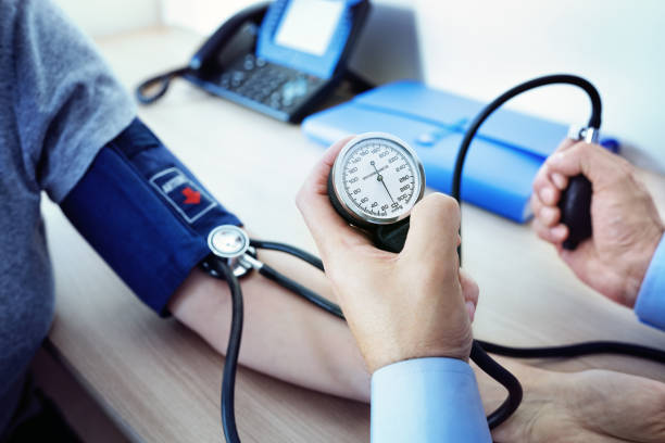 médico la medición de la presión arterial del paciente - medir tensión fotografías e imágenes de stock