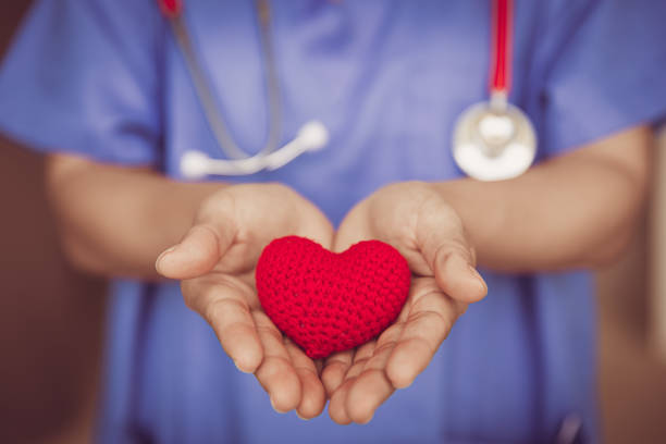 Doctor Nurse hand giving red heart for help care or blood donation healthcare share love to fight disease concept. stock photo