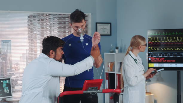 心臓呼吸検査のために酸素マスクでスポーツマンを準備する医師 - トレッドミル 呼吸 ストックフォトと画像