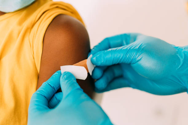 Doctor putting a bandage after Covid-19 vaccination. stock photo