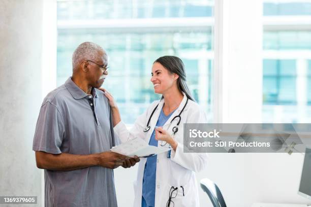 Doctor smiles and tries to encourage sad senior man