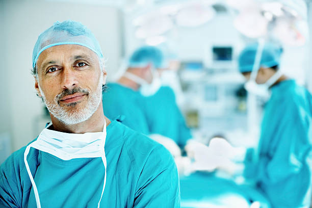 Doctor smiling in operating theater  surgeon stock pictures, royalty-free photos & images