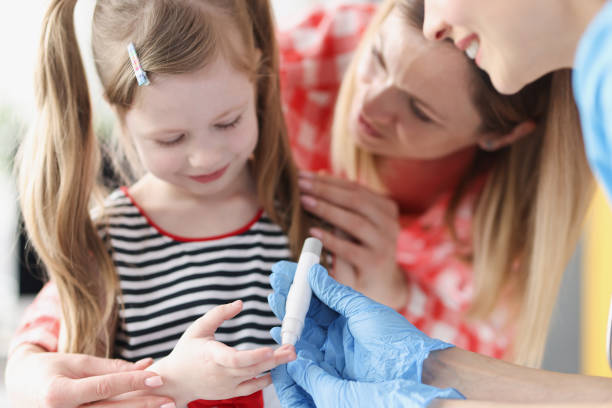 Doctor takes blood test with lancet from little girl stock photo