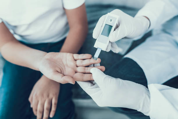 Doctor Taking Blood Sample from Boy's Finger. stock photo
