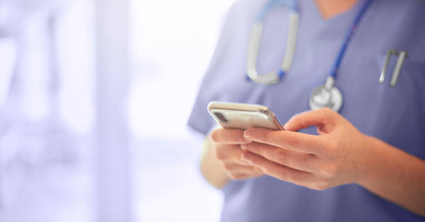 Doctor texting on mobile phone stock photo