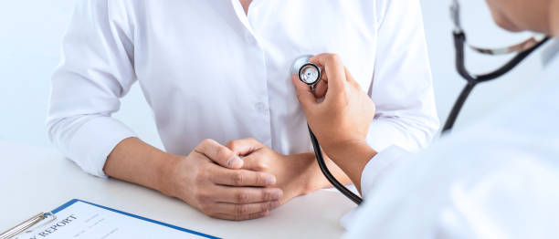 Doctor using a stethoscope checking patient about the problem of illness, sickness condition and recommend with examining treatment method stock photo